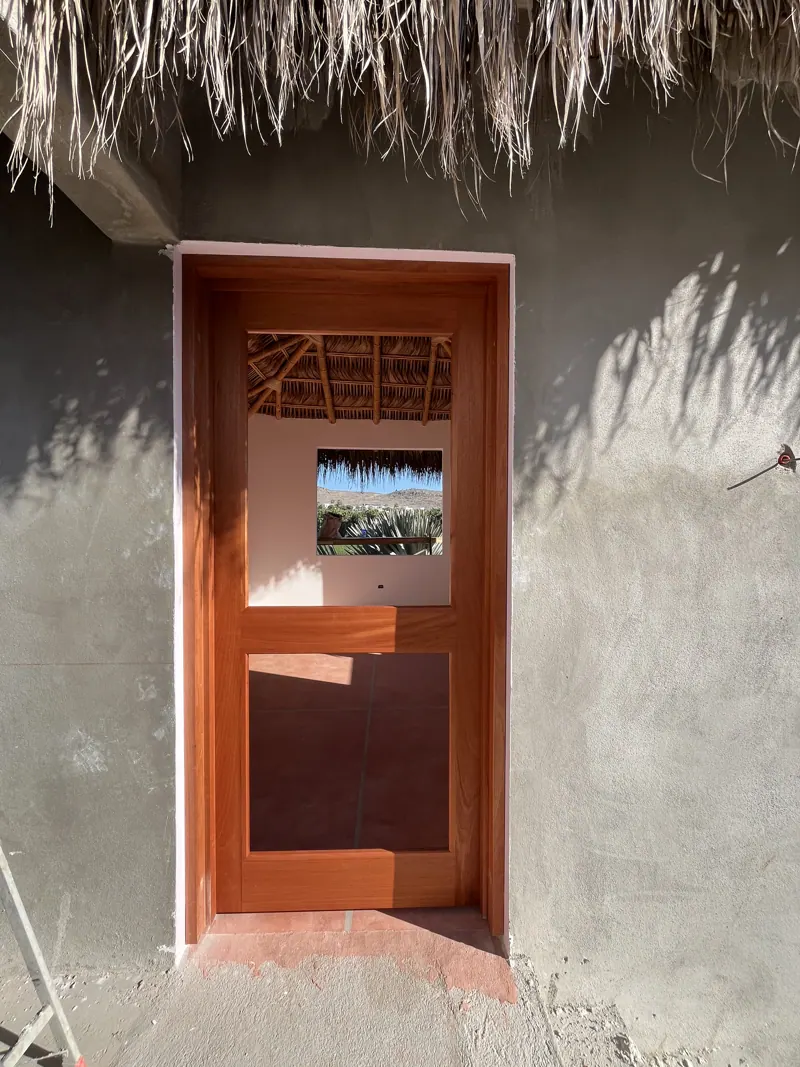 Wood screen door under a palapa roof